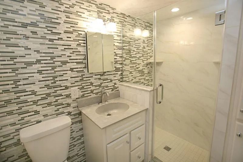 A bathroom with a toilet , sink , and shower.