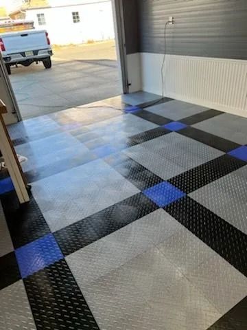 A truck is parked in a garage with a checkered floor.