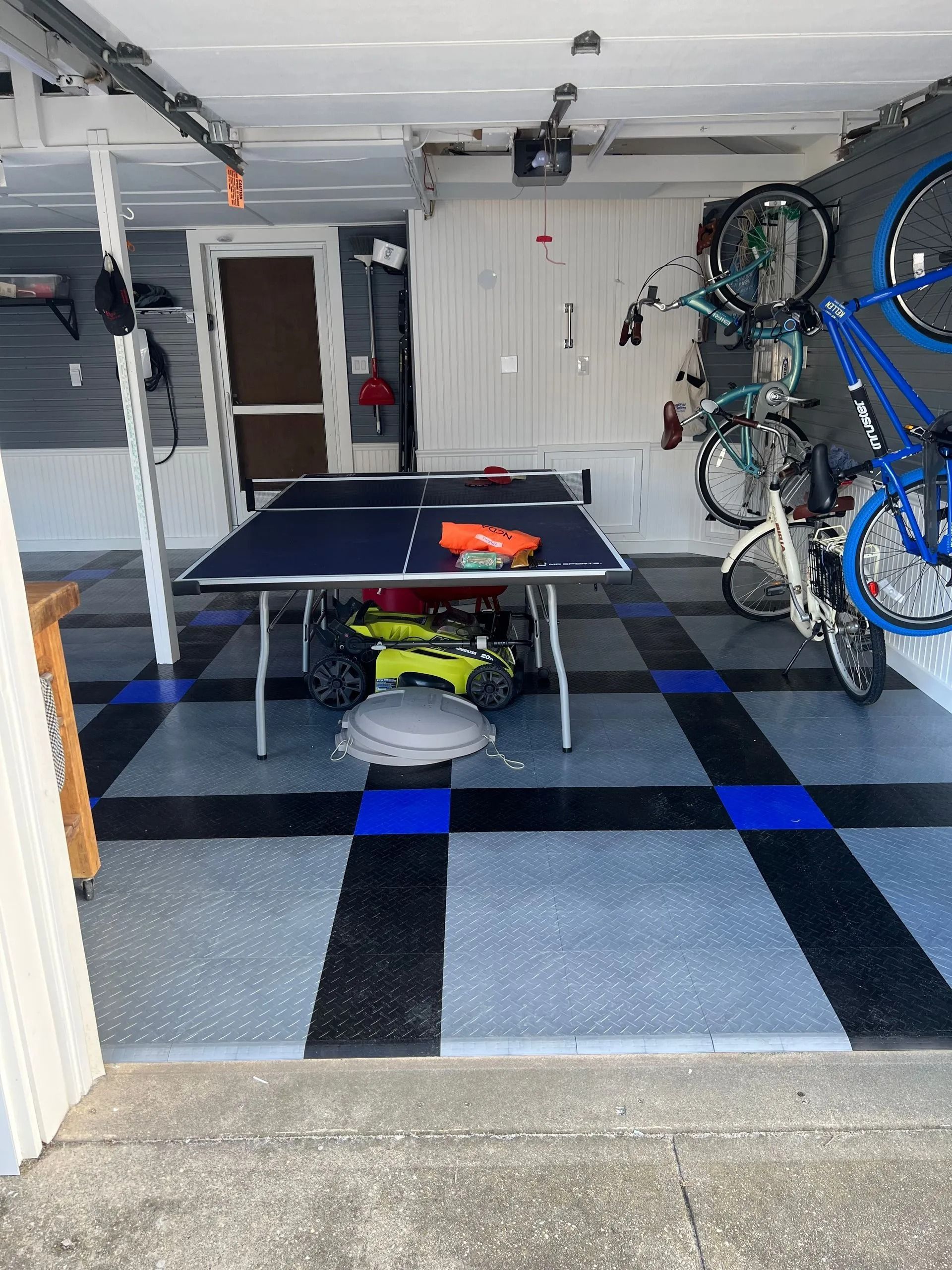 A garage with a ping pong table and bikes.