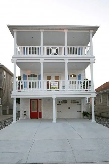 A large white house with a red door and balconies