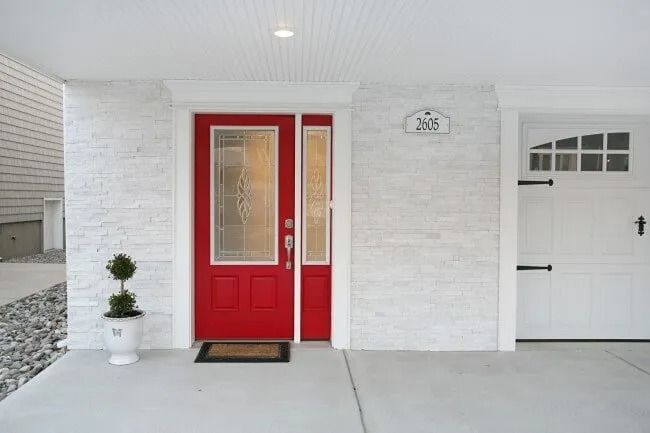 A white house with a red door and a white garage door