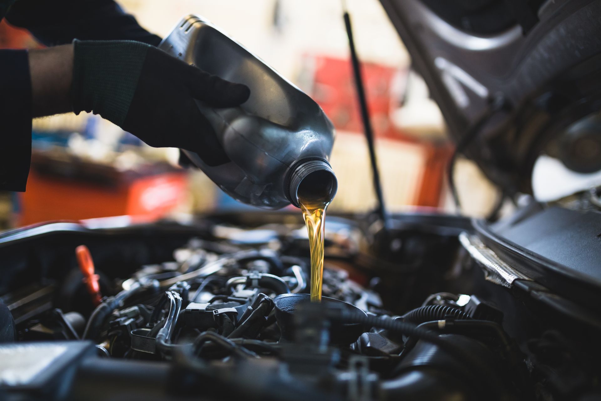 A man is changing the oil of a car.