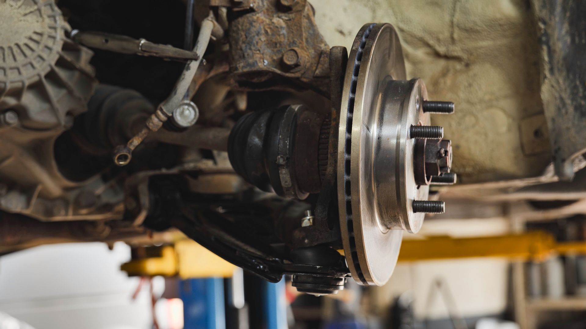 Car suspension and disc brake system undergoing maintenance.
