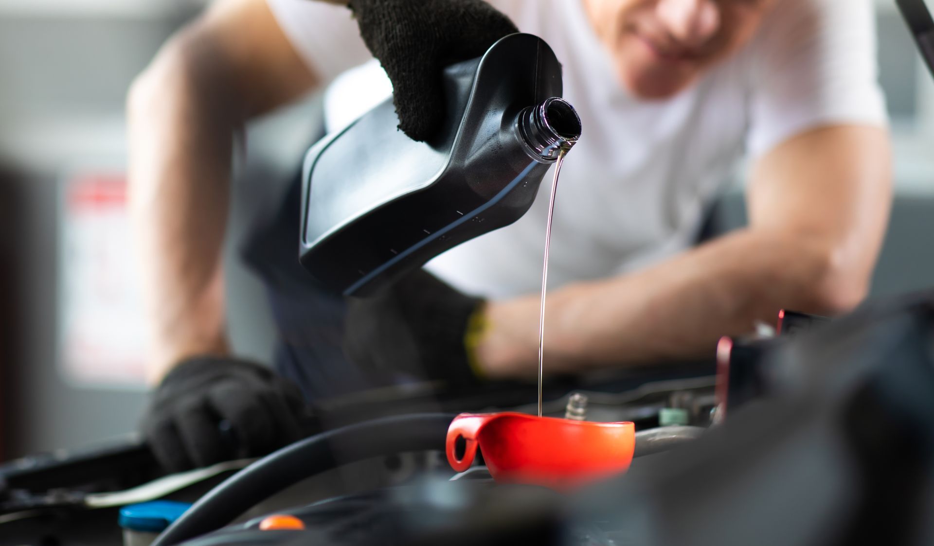 Pouring oil to car engine.