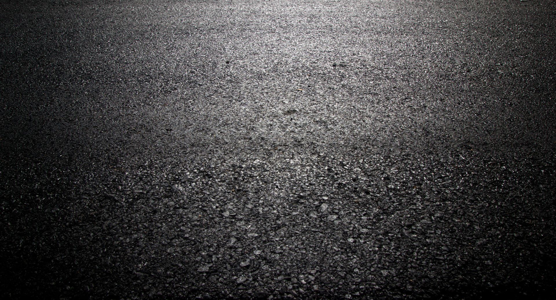 Close-up of freshly sealed driveway by an asphalt driveway contractor, glossy and detailed. Close-up of freshly sealed driveway by an asphalt driveway contractor, glossy and detailed.