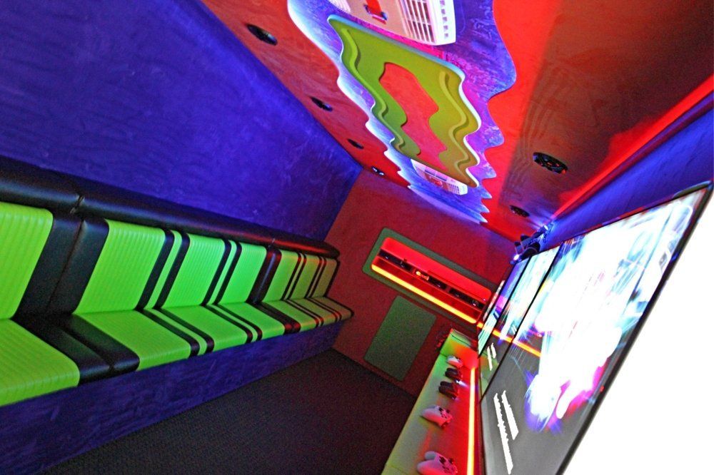 Brightly lit arcade interior with green seating and colorful ceiling design.