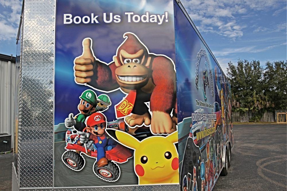 A trailer with a game-themed wrap. Donkey Kong gives a thumbs up. Mario, Luigi, Pikachu are also featured.