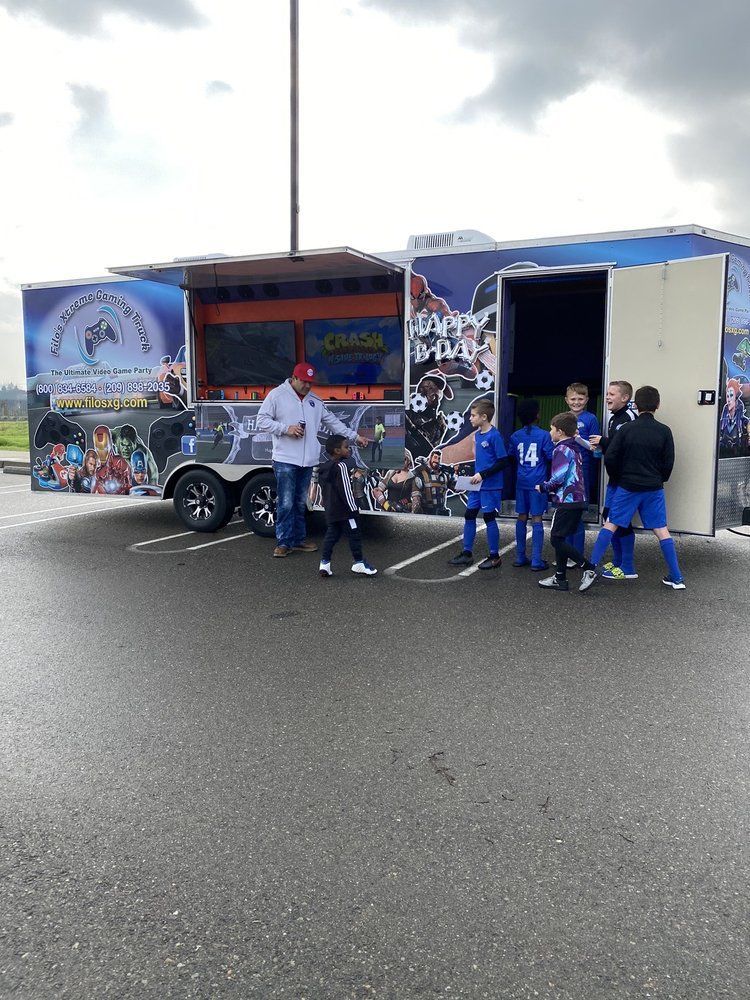 Soccer team with coach and trailer on a wet day.