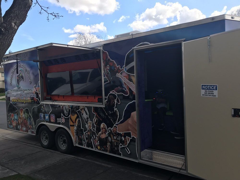 Gaming trailer with open doors and colorful superhero graphics.