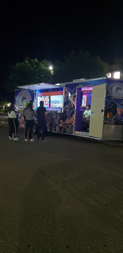 A food truck is open at night, with several people standing outside.