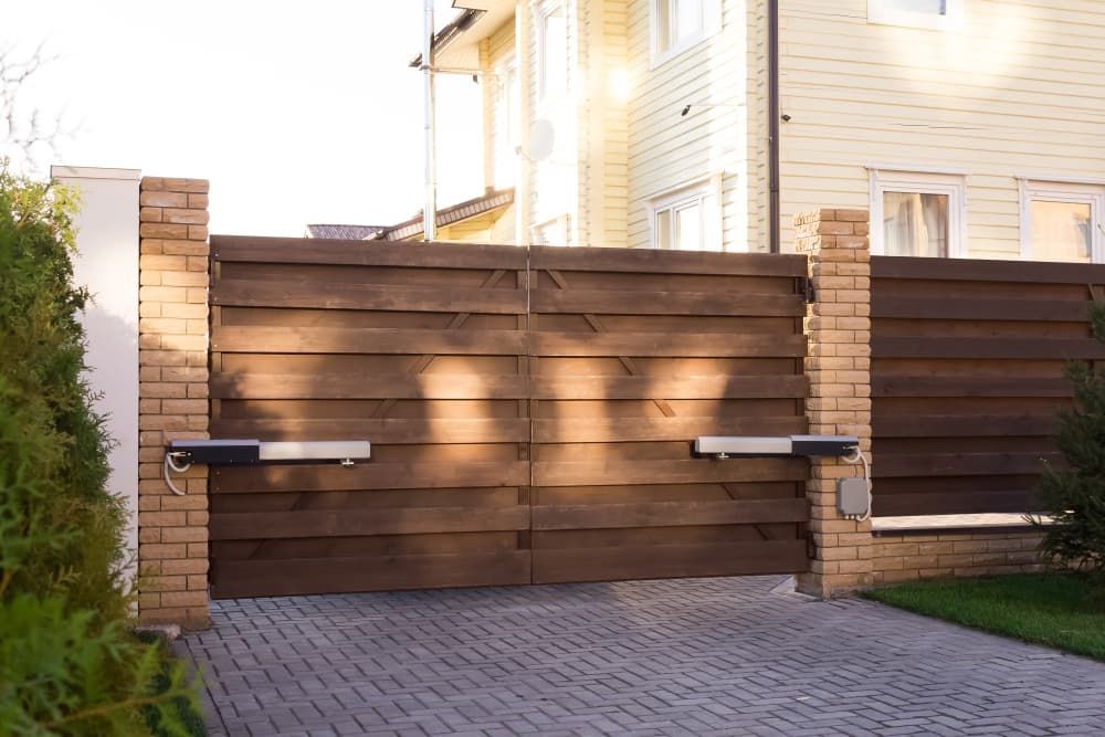 A Wooden Gate Is Open To A Driveway In Front Of A House — The Roller Door Man NQ In Portsmith, QLD