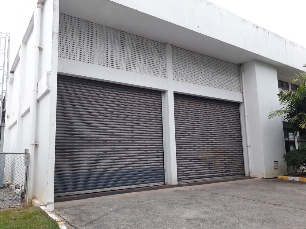 A Large White Building With a Lot of Garage Doors — The Roller Door Man NQ In Mareeba, QLD