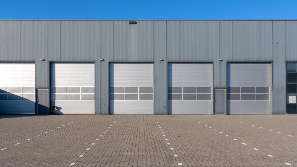 A Row Of Garage Doors On The Side Of A Building — The Roller Door Man NQ In Portsmith, QLD