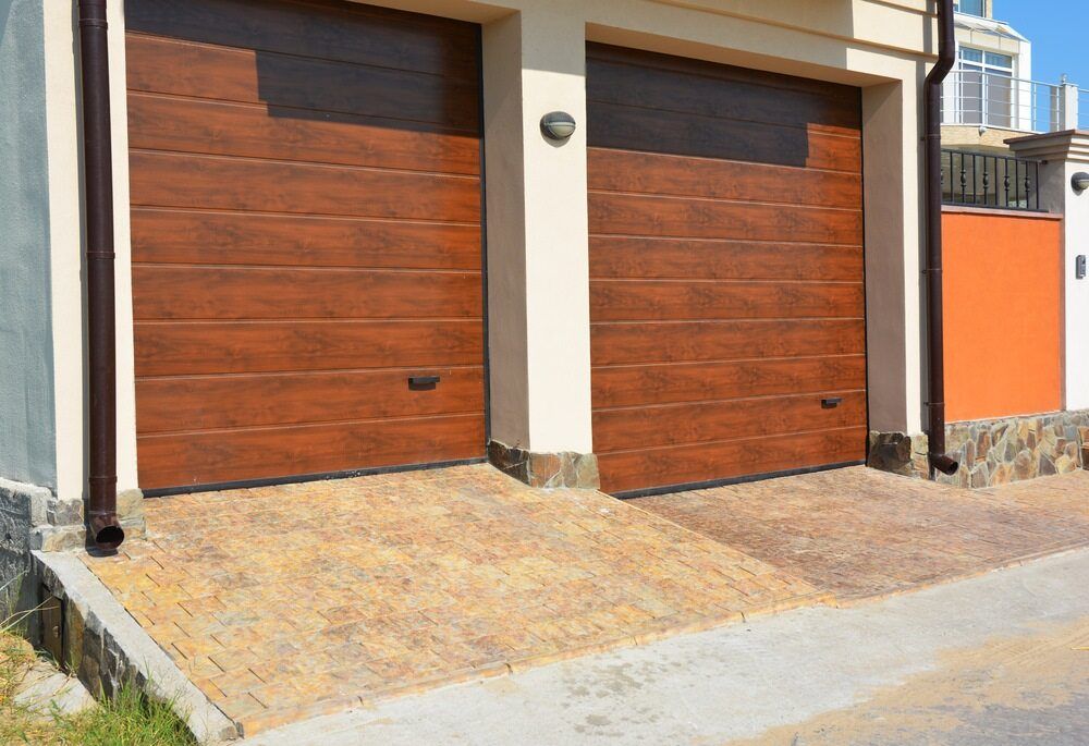 Two Wooden Garage Doors Are Sitting Next to Each Other on the Side of a House — The Roller Door Man NQ In Palm Cove, QLD