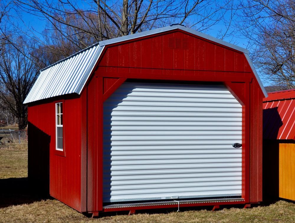 A Red Barn With A White Garage Door And A Window — The Roller Door Man NQ In Innisfail, QLD