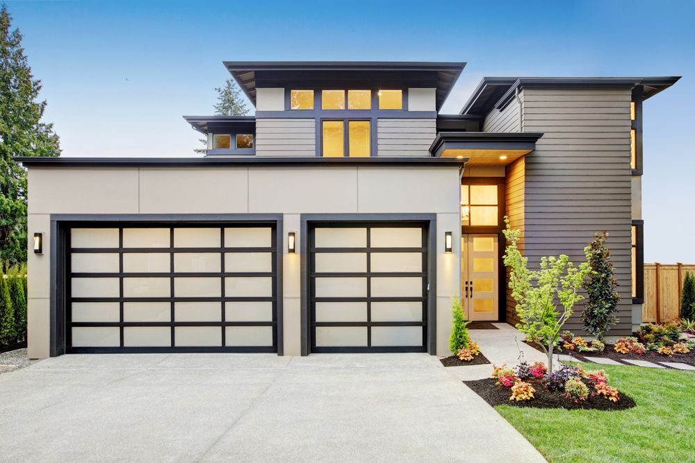 A Modern House With Two Garage Doors and a Large Driveway — The Roller Door Man NQ In Redlynch, QLD