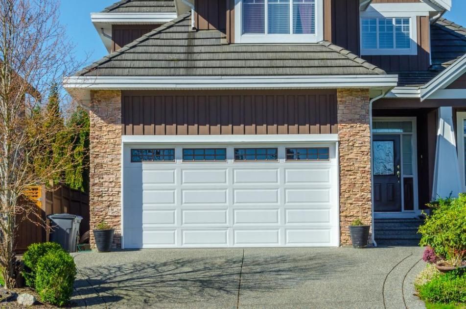 A Large House With A White Garage Door And A Driveway — The Roller Door Man NQ In Tablelands, QLD