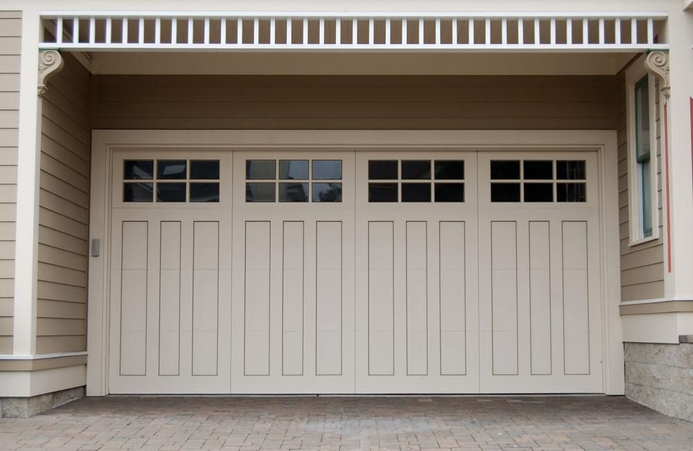 A White Garage Door Is Open To A House — The Roller Door Man NQ In Portsmith, QLD