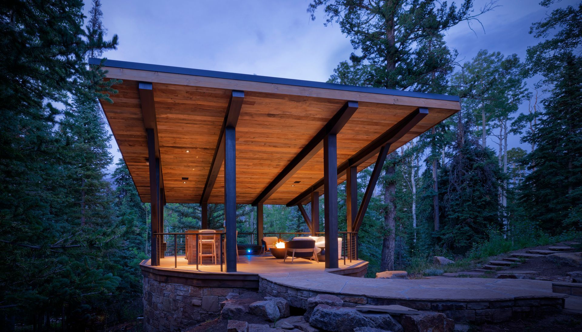 Elegant two-story house with a long, curved driveway, surrounded by trees and colorful landscaping.