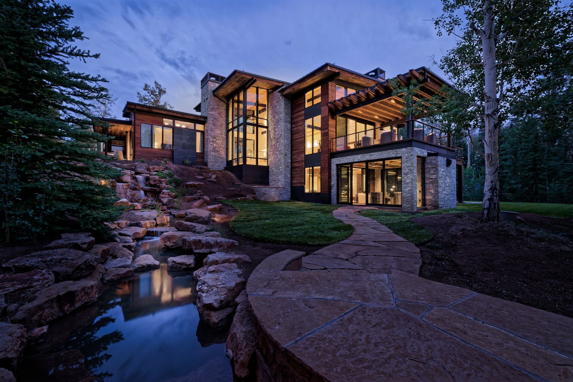 Luxury home with a pool, lounge chairs, and tropical landscaping.
