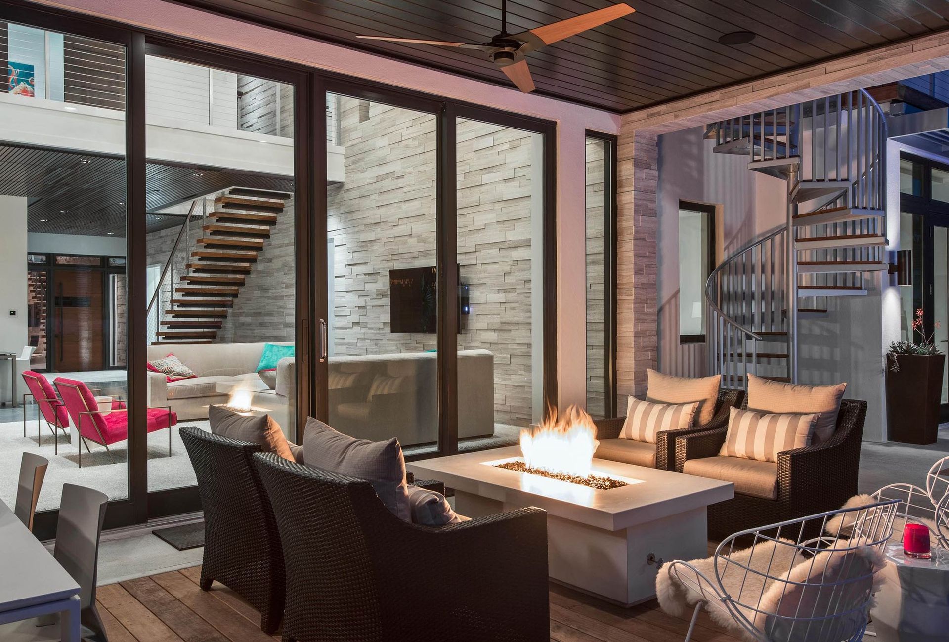 Outdoor patio with a fire pit, seating, and view of interior staircase.