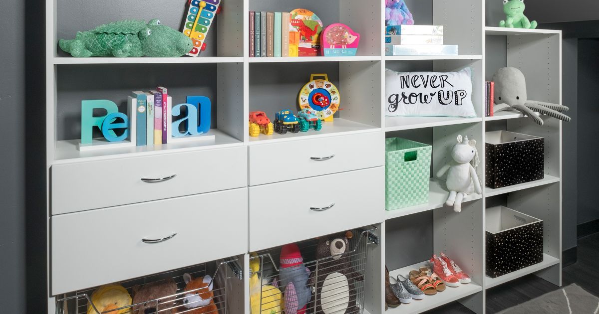 White cubby shelves filled with toys and decorative items against a gray wall.