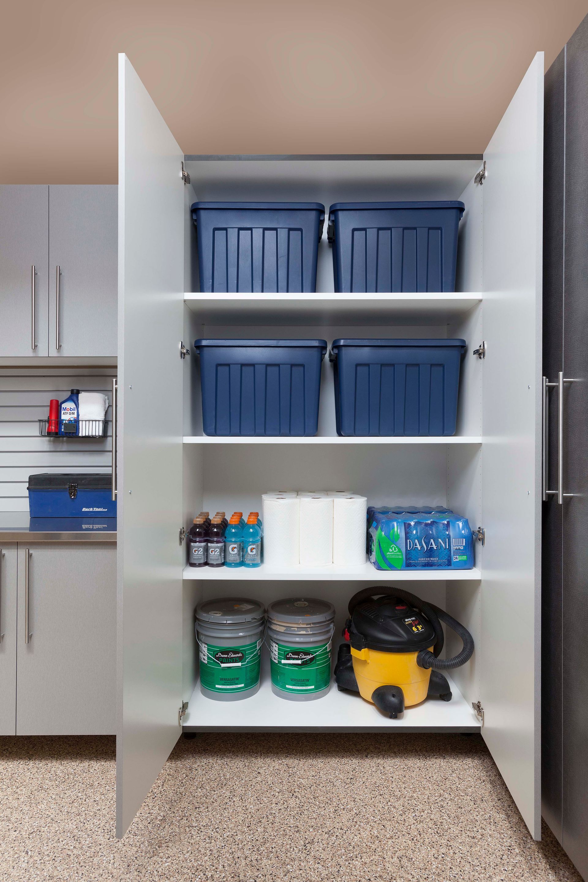 Garage interior with gray and white storage cabinets, wall organizers, and a door.