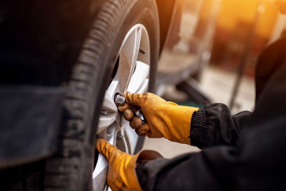 Auto Mechanic Man With Wheel Car — Tyre Service in Blackall Tambo, QLD