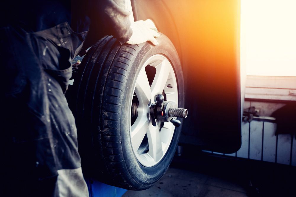 Repairman Balances The Wheel And Installs — Tyre Service in Blackall Tambo, QLD