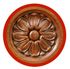 Medaglione circolare in legno raffigurante un fiore intagliato a dieci petali con un centro prominente, racchiuso da un bordo rosso.