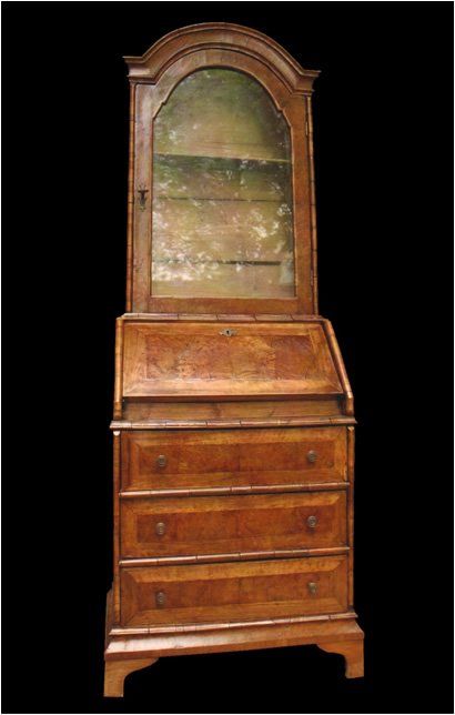 Un'antica scrivania in legno con un vano superiore con ante in vetro, un piano di scrittura a ribalta e tre cassetti inferiori.