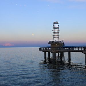 A pier with a lighthouse on top of it in the middle of the lake in Burlington.