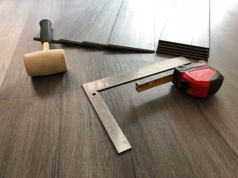 A Hammer, Ruler And Tape Measure Are On A Wooden Floor —  Cabonne Carpets In Molong, NSW
