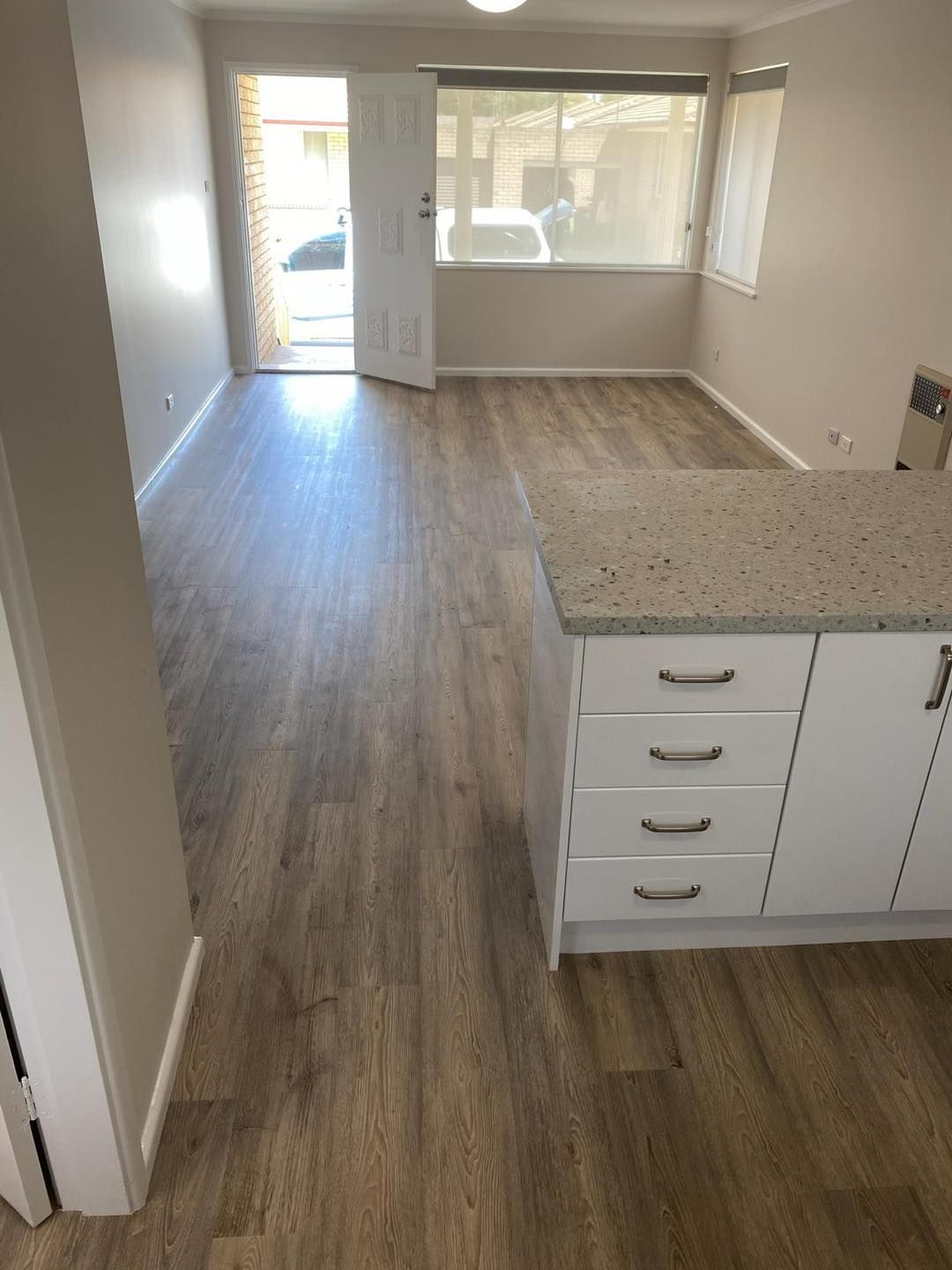 A Kitchen With A Wooden Floor , White Cabinets And A Granite Counter Top —  Cabonne Carpets In Molong, NSW