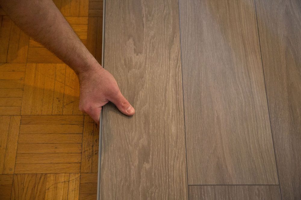 A Person Is Pointing At A Piece Of Wood On A Wooden Floor —  Cabonne Carpets In Molong, NSW