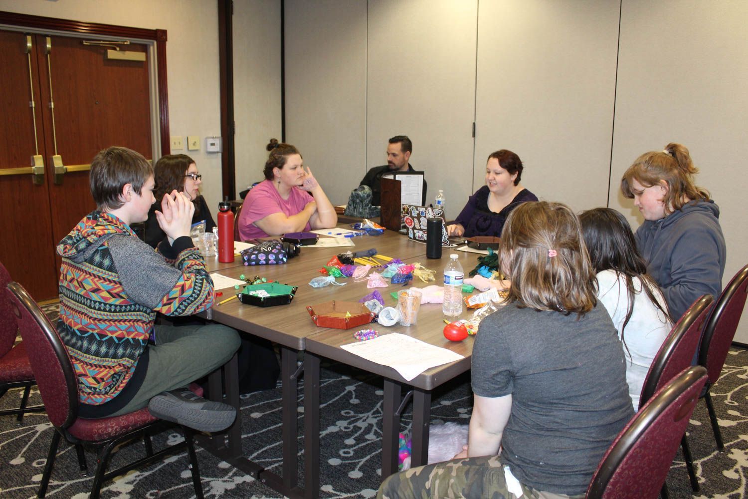 A group of people are sitting around a table in a room.