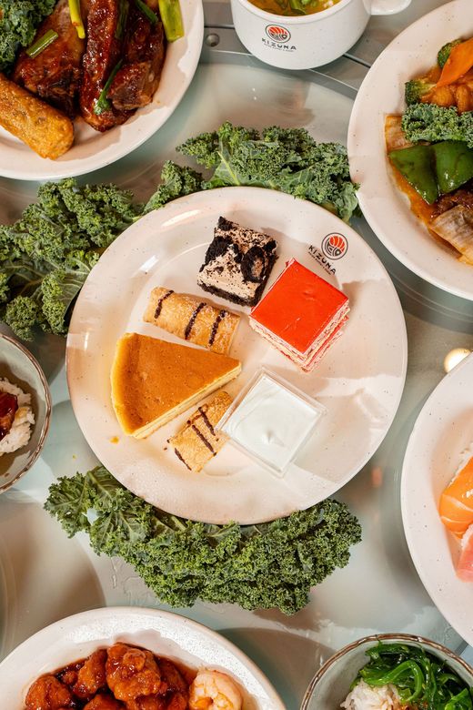 Assorted desserts on white plates arranged on a table with greenery