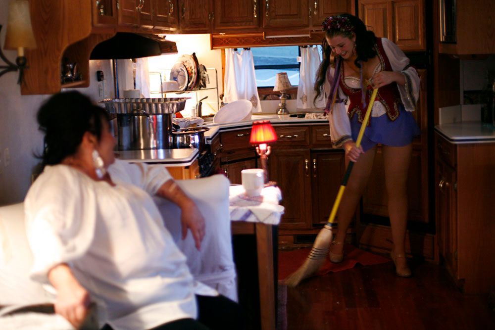 Sandra talks with Tosca as she sweeps up the trailer between shows. Normally Tosca would have changed before sweeping up but they are expecting dinner guests after the final show and there was little time to clean up and cook between the shows.