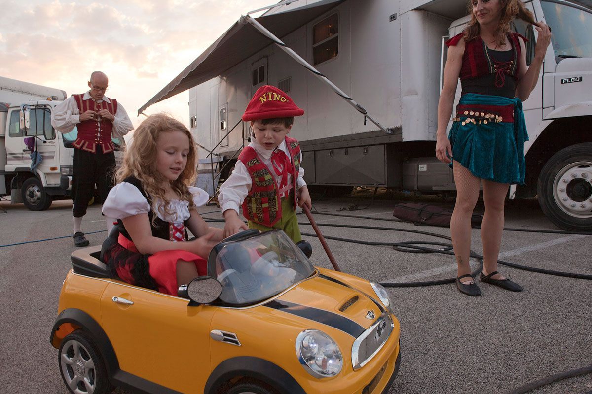 Circus kids play around in the back lot while their parents get ready for the next show.