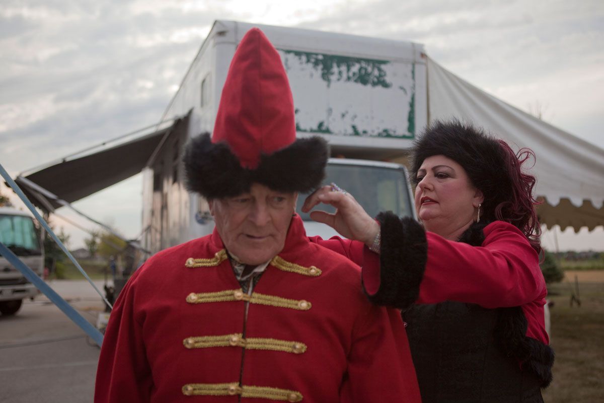 Carla adjusts Rudy's costume before they head into the ring to perform with their dogs. 