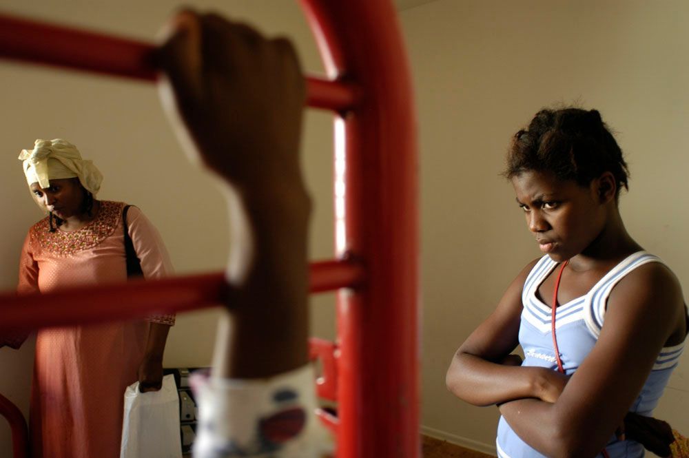 Asiya and Aline watch as their bed is dismantled in order to take it downstairs. Aline is upset at her mother for moving the family to Indiana because her friends are in Chicago. The family is moving because rent is less expensive and public aid is easier to receive in Indiana.