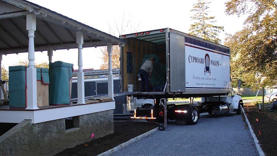 A moving company truck is parked in front of a house
