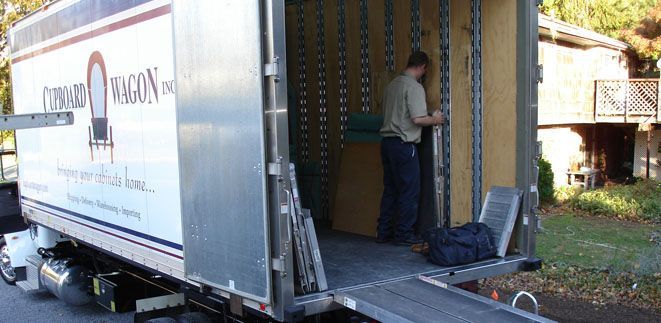 A man is standing in the back of a moving truck from Cupboard Wagon cabinet delivery services
