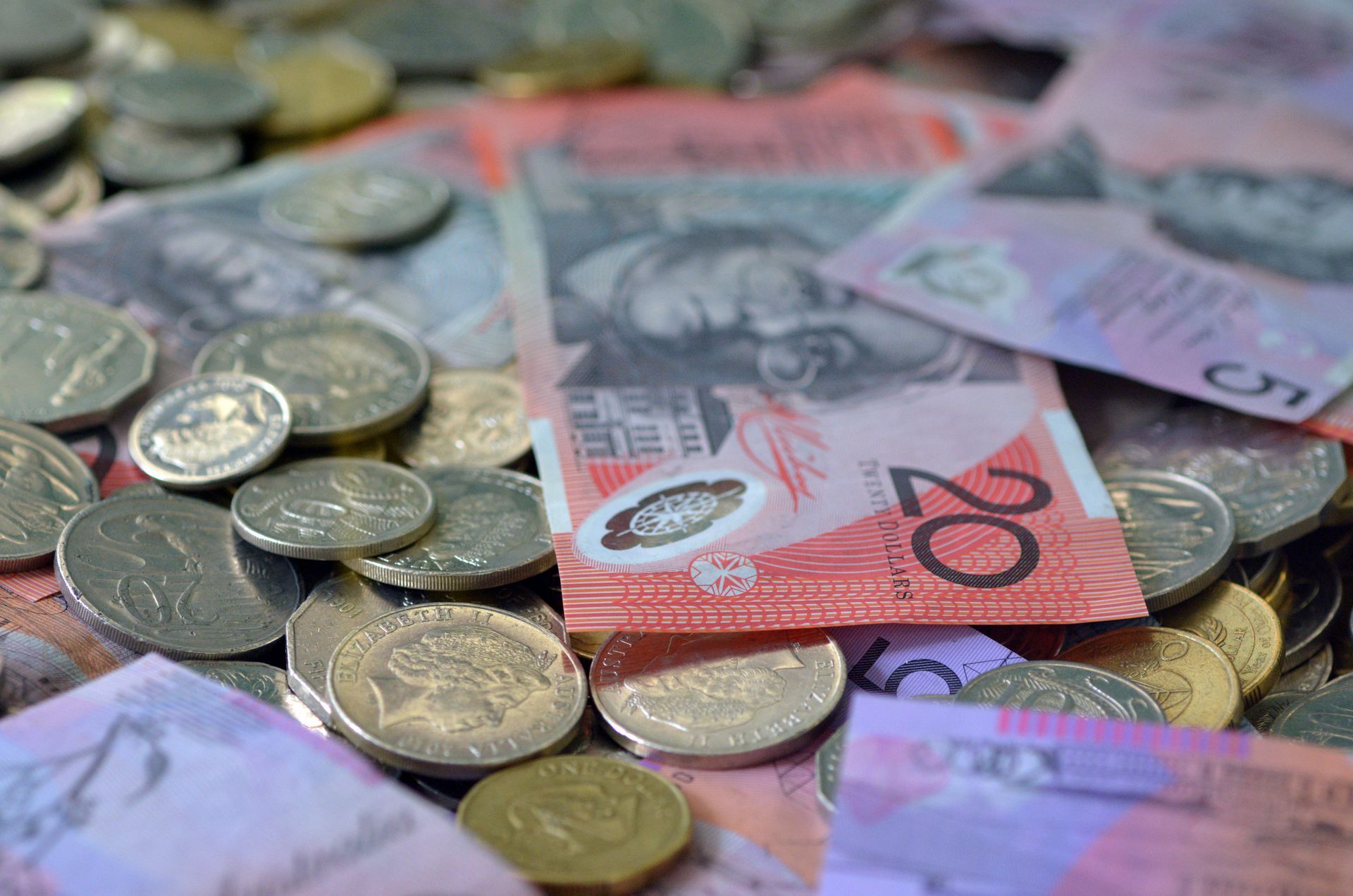 Australian currency: twenty-dollar bills and assorted coins scattered on a surface. Australian currency: twenty-dollar bills and assorted coins scattered on a surface.