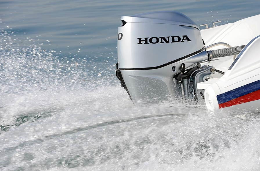 Il motore fuoribordo Honda agita l'acqua su una barca, creando schizzi.