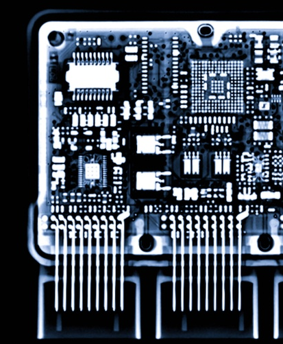 Immagine a raggi X di un circuito stampato, che mostra intricati componenti elettronici e cablaggi.