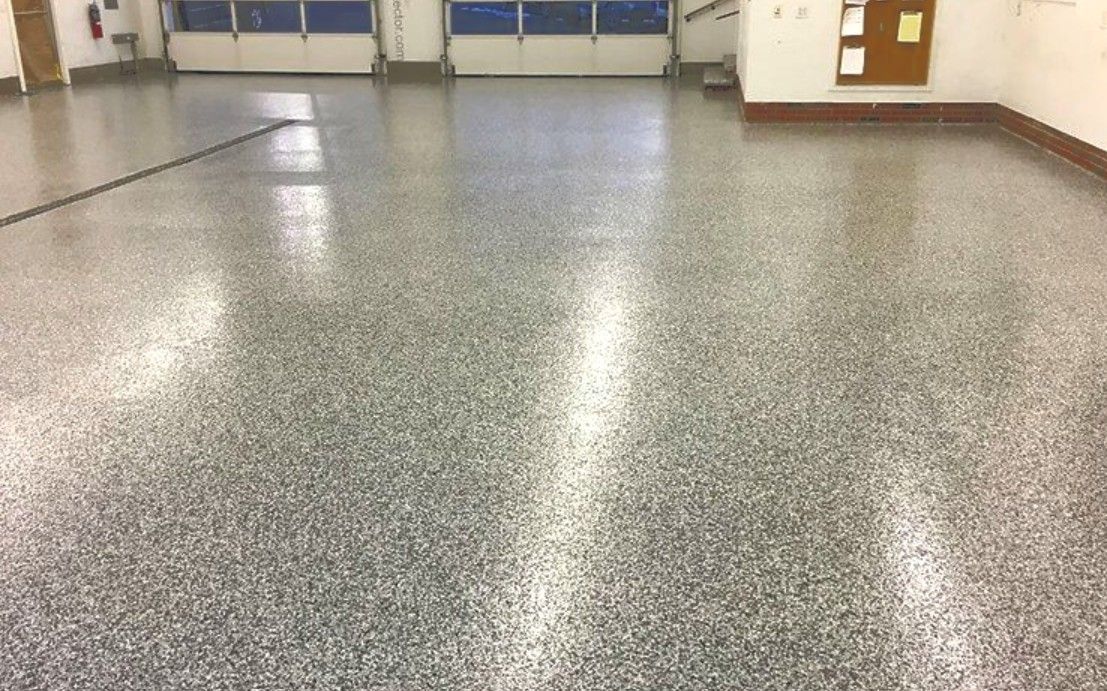 Large flake-coated floor in a spacious working garage or utility space, showing a durable, finished surface designed for everyday function, daily activity, and practical use.