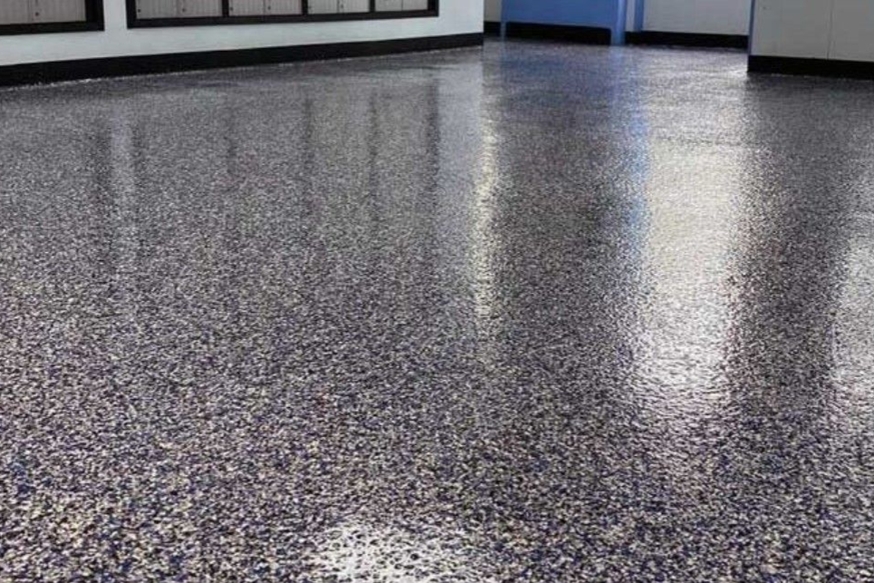 Cleveland Epoxy & Coating Pros contractor using a floor buffer on a bare concrete floor inside a garage to prep for epoxy install.