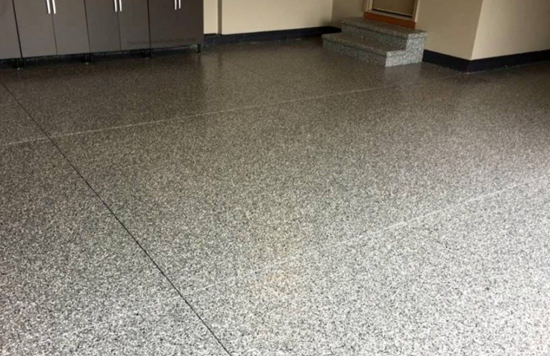 Neutral gray flake floor coating in a clean garage, showing a refined finished appearance that feels upgraded without looking overly flashy.