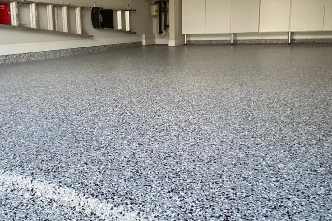 Empty speckled blue and gray flake epoxy floor in a Cleveland area garage.